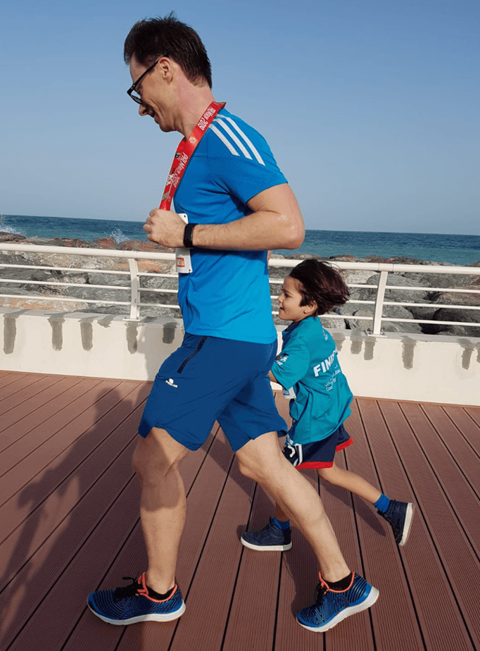 Klaus on a run with his kid by the sea